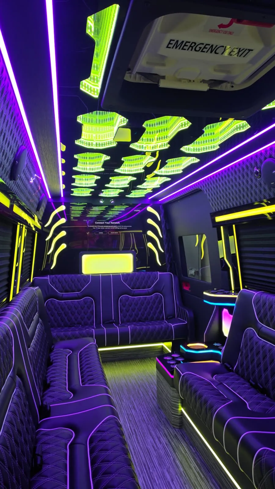 Limo Sprinter interior with perimeter lounge seating and purple and green ambient lighting