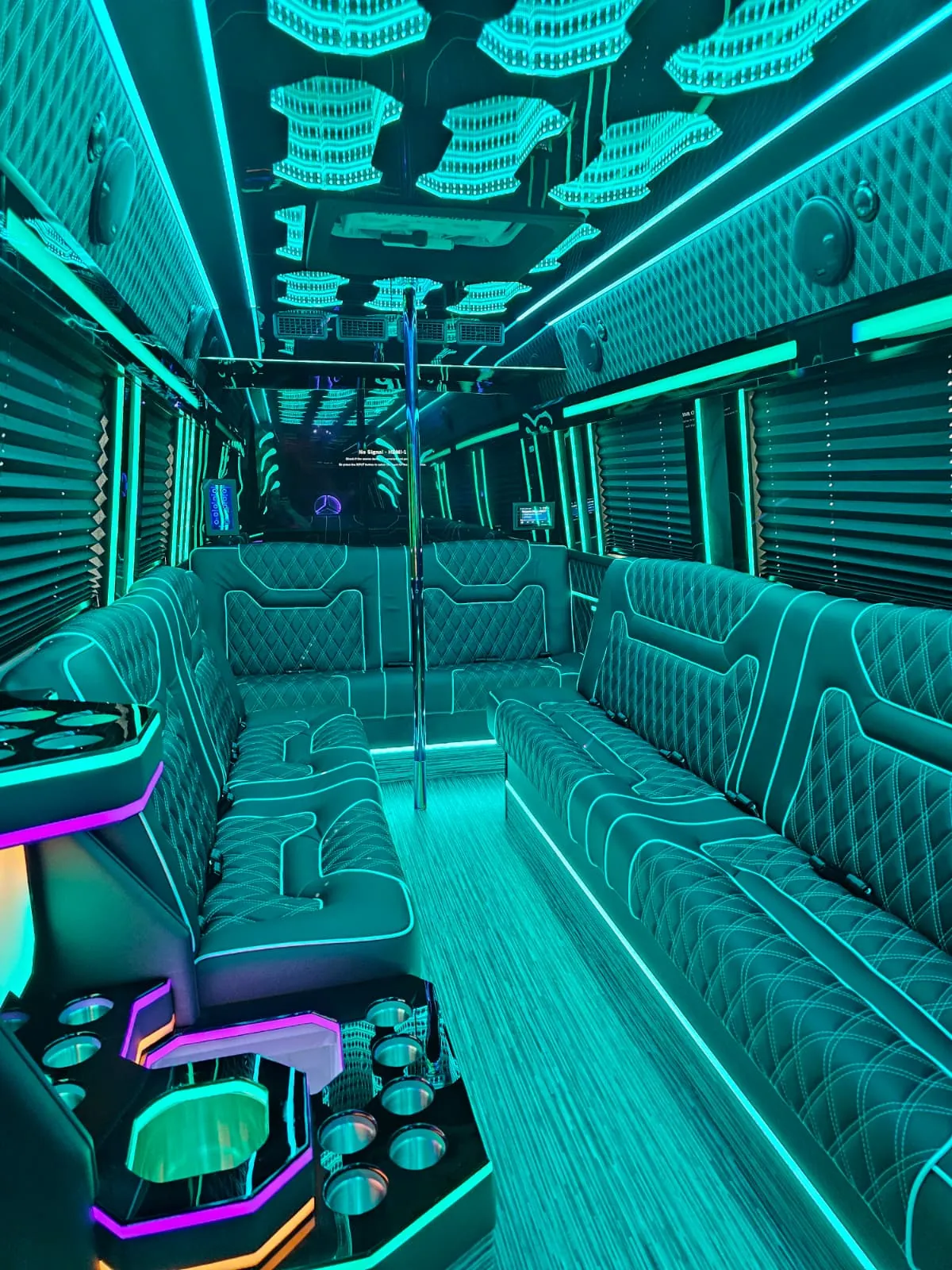 Limo Sprinter interior with perimeter lounge seating and turquoise ambient lighting