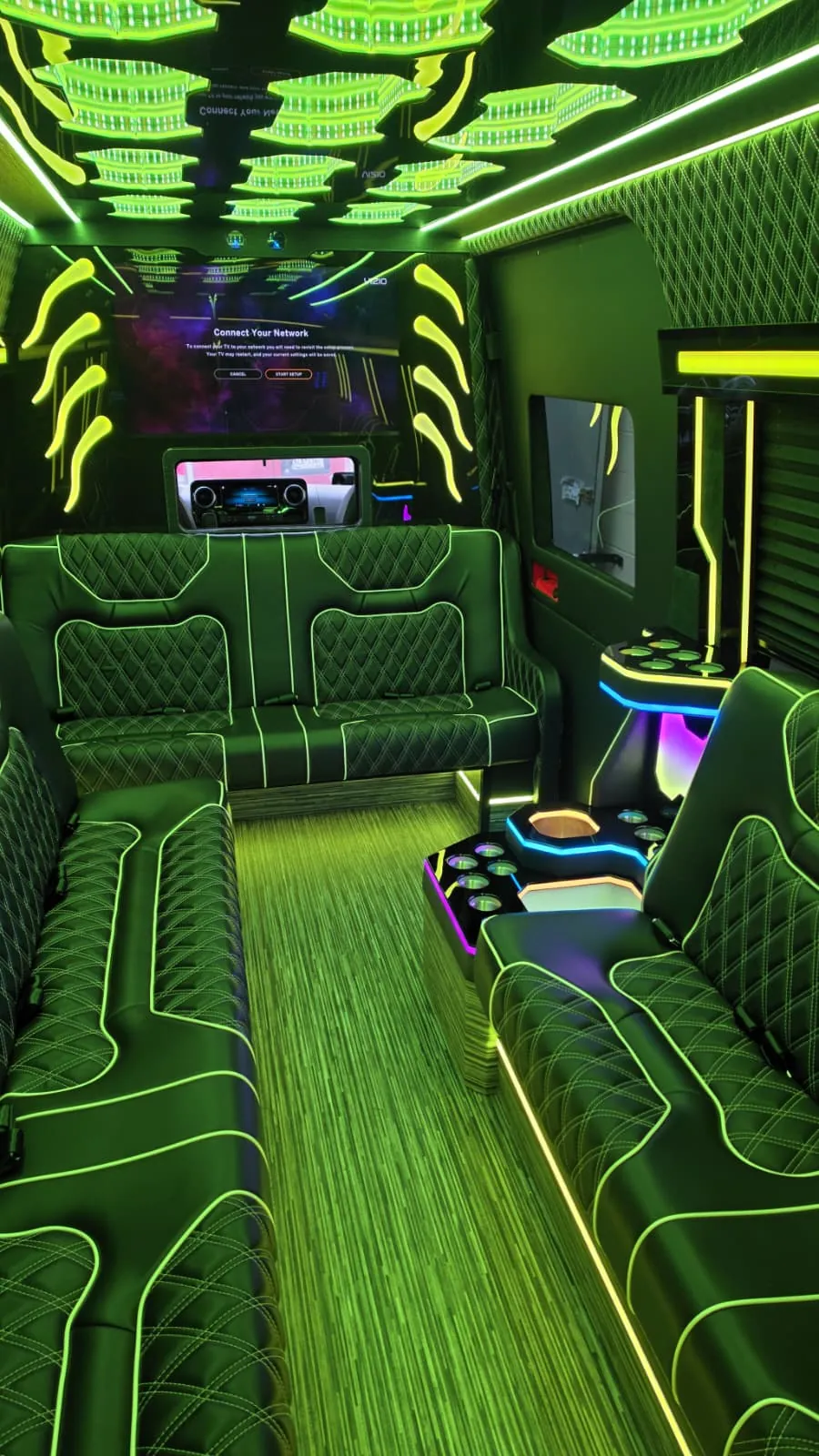 Limo Sprinter interior with perimeter lounge seating and green ambient lighting